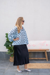 Vista lateral de blusa azul con lunares negros y mangas abullonadas, estilo casual y femenino