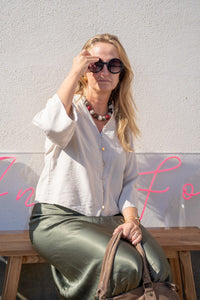 Look relajado con blusa beige, falda satinada verde aceituna y gafas de sol, estilo natural y sofisticado de AnnFou