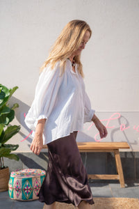 Vista lateral de la blusa blanca abullonada de algodón, combinada con falda satinada, estilo relajado AnnFou
