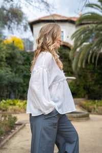 Blusa blanca con manga abullonada y corte suelto, detalle romántico y tejido ligero

