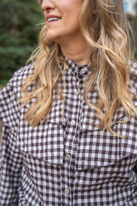 Vista frontal de la blusa vichy marrón con volantes, estilo casual y femenino

