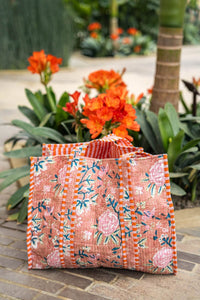 Bolsa tote de algodón 100% con estampado floral sobre fondo salmón y asas con rayas naranjas y blancas, estilo artesanal AnnFou