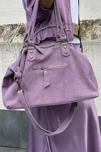 Detalle del bolso shopper de ante malva con asas dobles y bolsillo frontal con cremallera