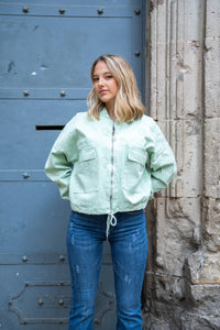 Chaqueta bomber verde agua con textura bordada, cierre de cremallera y bolsillos con solapa