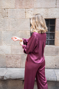 Vista trasera de la camisa satinada burdeos, tejido brillante y diseño relajado