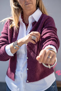 Cárdigan de alpaca en color burdeos con botones de nácar, corte recto ligero, combinada con camisa blanca AnnFou