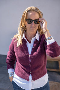 Cárdigan de alpaca burdeos con botones de nácar en vista frontal, corte recto y ligero, combinada con camisa blanca AnnFou