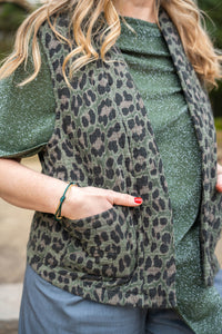 Detalle del chaleco verde militar con estampado animal print y bolsillos laterales, tejido acolchado

