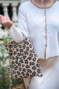 Detalle de chaqueta beige con ribete camel, botones nacarados y tejido fino