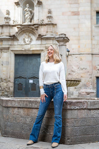 Chaqueta de punto fino blanca con botones tipo bola dorados, diseño limpio y versátil