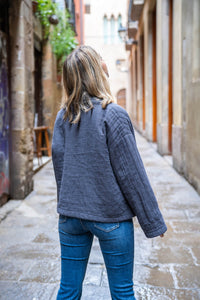 Vista trasera de la chaqueta gris acolchada, corte relajado y textura mullida para entretiempo