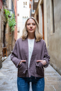 Chaqueta acolchada de algodón en tono marron, con lazo cruzado a la cintura y bolsillos prácticos