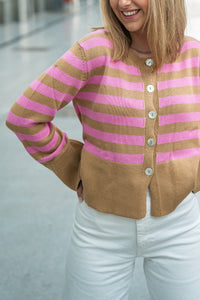 Detalle de la chaqueta rayada en tonos camel y rosa chicle, tejido ligero con botonadura brillante

