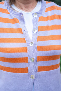 Detalle de la chaqueta de punto rayada con botones nacarados y tejido fino en tonos vivos

