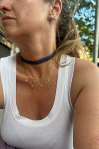 Choker índigo de tejido textil con fruncido, estilo casual elegante sobre cuello de mujer

