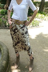 Falda midi satinada con estampado animal print de vaca, combinada con cinturón ancho y botines taupe