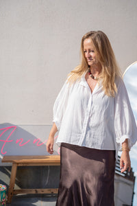Falda satinada marrón en look completo con blusa blanca abullonada, estilo natural y luminoso AnnFou