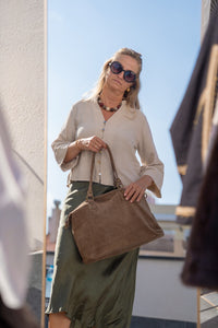 Falda satinada en verde aceituna combinada con blusa beige y bolso marrón de ante, look elegante de AnnFou
