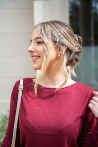 Detalle del jersey burdeos con cuello lurex, escote redondo y tejido ligero