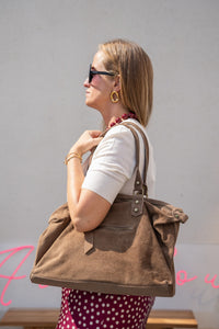 Jersey de punto crudo de manga corta con bolso grande de ante marrón al hombro, vista lateral con collar burdeos
