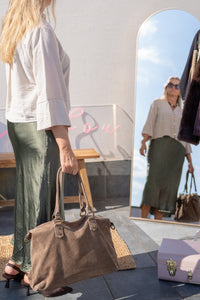 Reflejo en espejo de look con blusa beige, falda satinada verde aceituna y bolso marrón de ante, estilo relajado de AnnFou