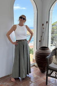 Pantalón falda verde de tejido fluido con cinturón marrón, corte amplio y estilo relajado de verano