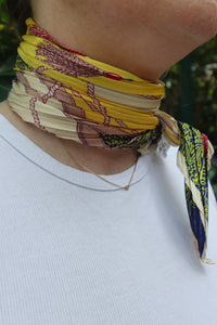 Vista lateral del pañuelo plisado amarillo con diseño navy, anudado al cuello con detalle elegante de AnnFou